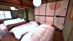 a bedroom with two beds and cabinets and a window at Waka no Yado -Oto- - Vacation STAY 17181 in Wakayama