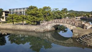 a stone bridge over a river in a city at Waka no Yado -Oto- - Vacation STAY 17181 in Wakayama