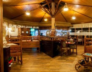 a restaurant with wooden tables and chairs and a bar at Ancora in Salonta