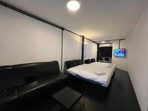 a room with a bed and a couch in it at 2Sleep DMK Airport Bangkok in Ban Ko