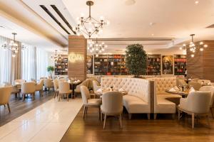 a restaurant with tables and chairs and a chandelier at Pepperclub Hotel in Cape Town