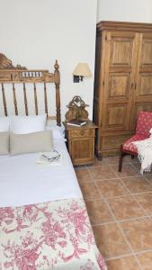 ein Schlafzimmer mit einem Bett und einem roten Stuhl in der Unterkunft Hotel Boutique Cumbres de Castilla in Mandayona