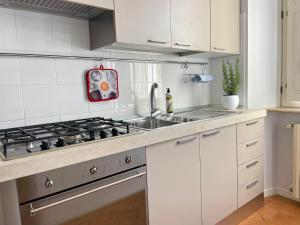 a white kitchen with a sink and a stove at Residenza Zaccone in Tivoli