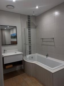 ダーバンにあるUmhlanga Apart Hotelのバスタブと洗面台のあるバスルーム +15枚の写真