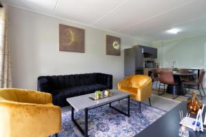 a living room with a couch and chairs and a table at #AlimamaSpaces Jade's Greenlee in Sandton