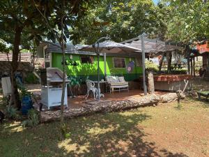 a green caravan with a patio in a yard at Casa das Fontes O Tocano in Válega