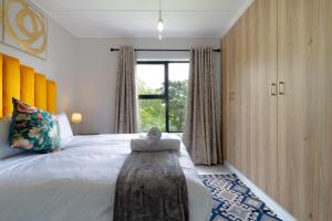 a bedroom with a large bed and a window at #AlimamaSpaces Jade's Greenlee in Sandton