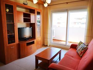 a living room with a red couch and a tv at Terrasol Torrelitoral 1 dormitorio in Torre del Mar +4 photos