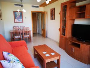 a living room with a couch and a tv and a table at Terrasol Torrelitoral 1 dormitorio in Torre del Mar