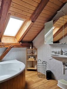 a bathroom with a large tub and a sink at Le Havre des Tourbières in Brot-Plamboz +7 photos