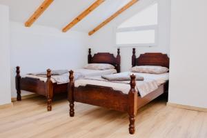 two beds in a room with wooden floors at Luxury Villa Marija Panoramic Pool & Nature Retreat in Podgorica +7 photos