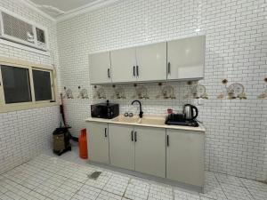 a kitchen with a sink and white brick walls at شقة جديدة ثلاث غرف نوم داخل حدود الحرم in Al Madinah
