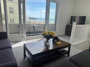 a living room with a vase of flowers on a coffee table at House by the Sea, Worthing in Worthing