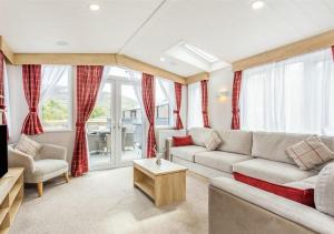 una sala de estar con un sofá y una mesa en Sanctuary 5 Hot tub lodge, en Fort Augustus