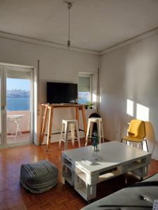 Sala de estar con mesa y 2 taburetes en Maré Bela, en Almada