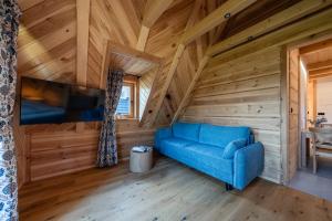 a living room with a blue couch in a wooden room at Apartamenty Tatra Loft in Ząb