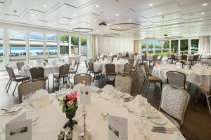 a conference room with tables and chairs with white tablecloths at Seehotel Waldstätterhof Swiss Quality in Brunnen