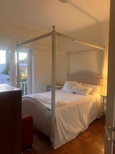 ein Schlafzimmer mit einem Himmelbett mit weißen Laken in der Unterkunft Vila Nogueira De Azeitao - Amaral's Guest Houses in Villa Nogueira + 52 Fotos