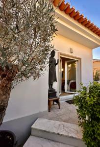 Eine Statue einer Frau, die vor einem Haus steht. in der Unterkunft Vila Nogueira De Azeitao - Amaral's Guest Houses in Villa Nogueira