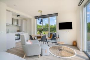 a living room with a table and chairs and a tv at Mereveld Studios in Utrecht