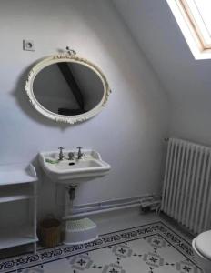 a bathroom with a sink and a mirror on the wall at Villa Alice centre village proche forêt in Barbizon