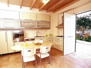 a kitchen with a wooden table and white chairs at Holiday Residence Rodanthi, Darmarochori in Darmarochori +14 photos
