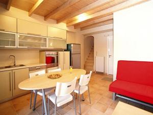 a kitchen with a wooden table and a red couch at Holiday Residence Rodanthi, Darmarochori in Darmarochori
