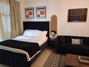 een slaapkamer met een groot bed en een bank bij Luxury studio At The Loftel ruaka in Ruaka +35 foto's