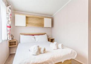 Un dormitorio con una cama blanca con almohadas blancas. en Sanctuary 10 Hot tub lodge, en Fort Augustus