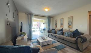 una sala de estar con un sofá y una mesa en Stylish stay at Hartensee, en Mossel Bay