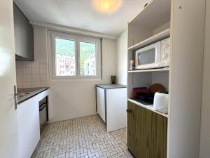 a small kitchen with a refrigerator and a microwave at Mayenzett 34 in Leukerbad