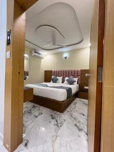 a bedroom with a large bed with a marble floor at Hotel Plus Point in Ahmedabad +18 photos