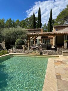 a swimming pool in front of a house at Le Mas de la Rose in Taradeau