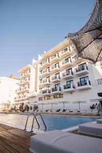 un hotel con piscina frente a un edificio en Chimaera Hotel, en Himare