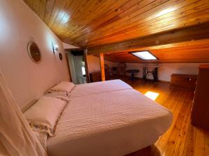 a bedroom with a bed in a room with wooden ceilings at La Casina del Arroyo in Poo de Cabrales