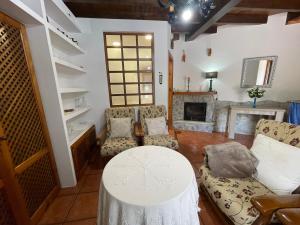 a living room with a table and chairs and a fireplace at La Casina del Arroyo in Poo de Cabrales
