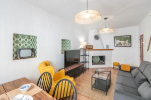 a living room with a couch and a table and chairs at Casa Ramoncico Pampaneira in Pampaneira