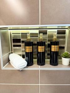 een plank met vier zwart-gouden brandblussers in een badkamer bij Local-Lux Apartman 3 szoba, privát parkoló in Kecskemét