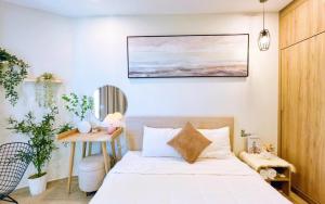 a bedroom with a bed and a painting on the wall at The Sóng Condotel Hao's Homestay in Vung Tau