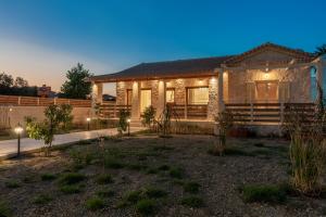 een huis met lichten in een tuin 's nachts bij Aurum Luxury Villa Voz by elite" in Laganas