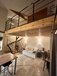 a living room with a loft bed and a table at Gîte les Millères - Le Duplex Cosy in Villemur-sur-Tarn