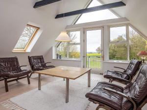 a living room with a table and chairs and windows at 8 person holiday home in Fur in Fur