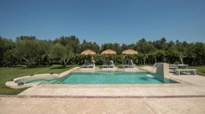 einen Pool mit Stühlen und Sonnenschirmen im Hof in der Unterkunft Vanesa Villa Retreat, 3BR with Lush Outdoor Oasis by Villa Mana Gers in Romírion