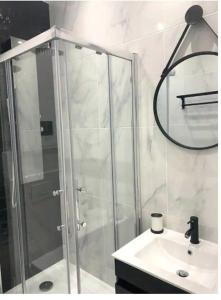 un baño con ducha y lavabo en Joli Appart 4pers#Buttes Chaumont#Chapeau Rouge, en París 2 fotos más