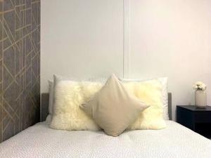 un grupo de almohadas sentado encima de una cama en Joli Appart 4pers#Buttes Chaumont#Chapeau Rouge, en París