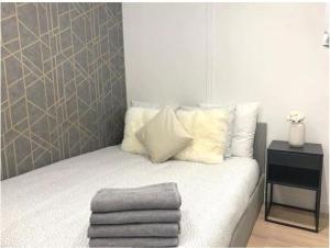 Dormitorio pequeño con cama con sábanas y almohadas blancas en Joli Appart 4pers#Buttes Chaumont#Chapeau Rouge, en París