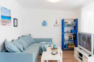 a living room with a blue couch and a tv at Family House GO TO - Parking & Dog Yard in Kavarna