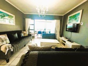 a living room with a couch and a tv at Tahiti Dreaming in Umdloti