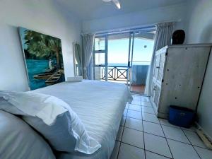 a bedroom with a bed and a view of the ocean at Tahiti Dreaming in Umdloti +14 photos