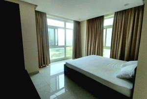 a bedroom with a bed and a large window at Beach 24 Residency in Muscat